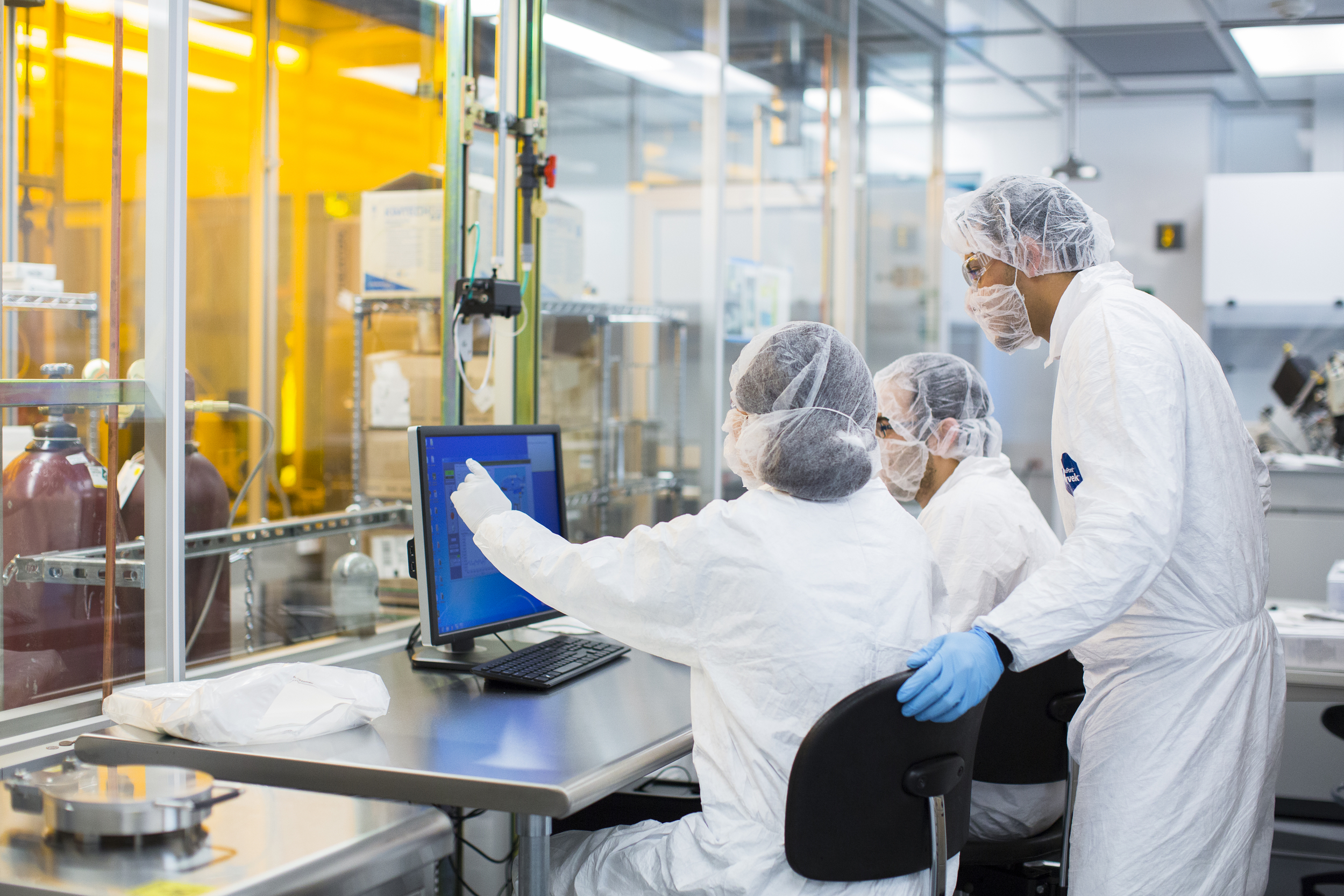 Stem cell laboratory with researchers reviewing information on computer monitor.